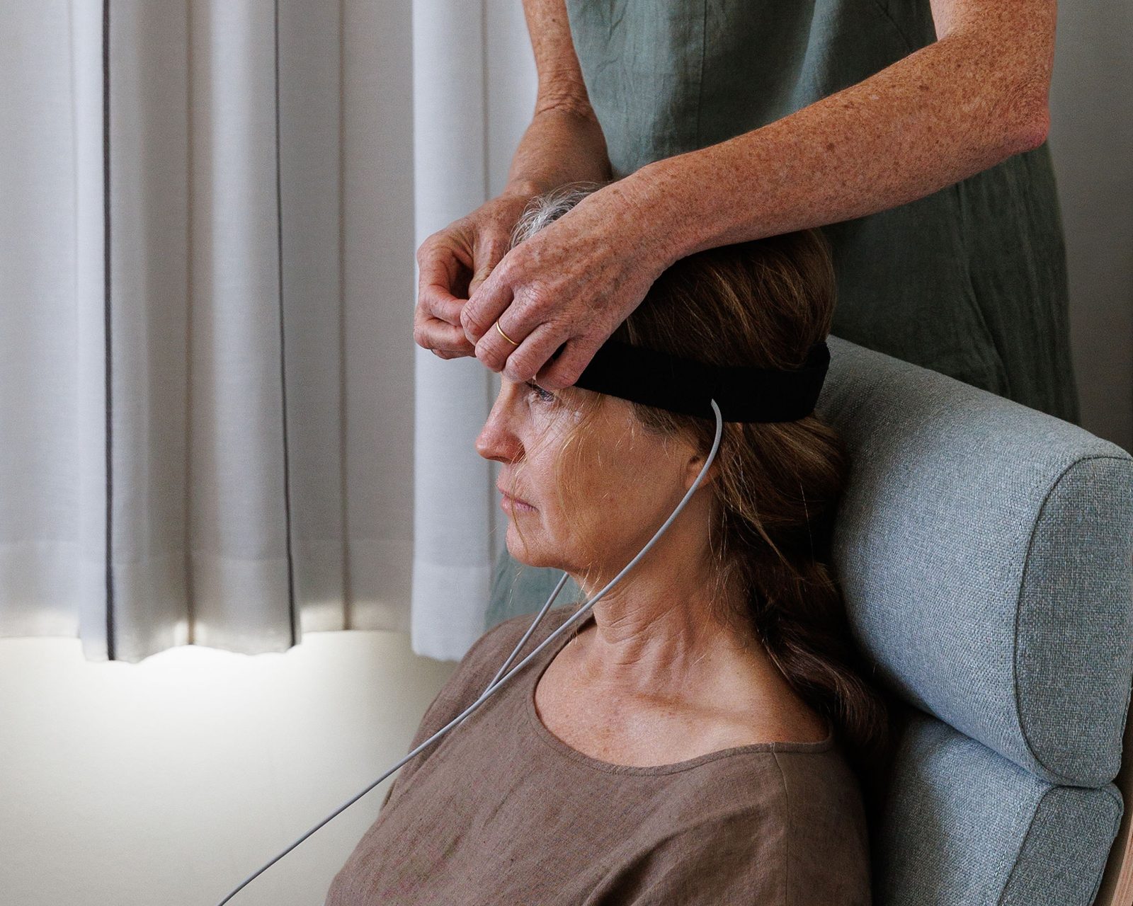 Caroline gently fitting the bioresonance headband for a client